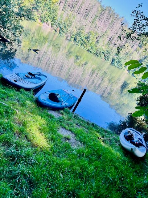 Zwei Boote am Wasser zwischen grünen Bäumen